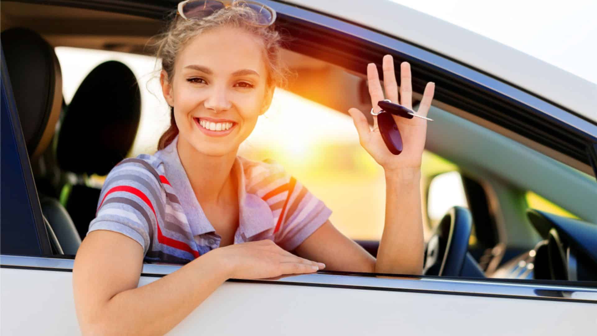 Jeune conductrice souriante avec ses clés de voiture au Luxembourg